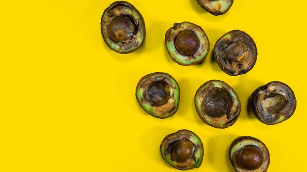 Many Bad Avocado on a yellow background. Creative composition of bad Food Fruits Avocado.Unhelthy food. Copy space on yellow.