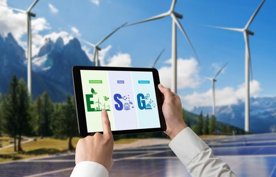 Green business transformation for environment saving and ESG business concept. Businessman using tablet to set corporate goal toward environmental friendly management and alternative clean energy use.