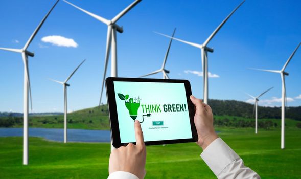 Green business transformation for environment saving and ESG business concept. Businessman using tablet to set corporate goal toward environmental friendly management and alternative clean energy use.