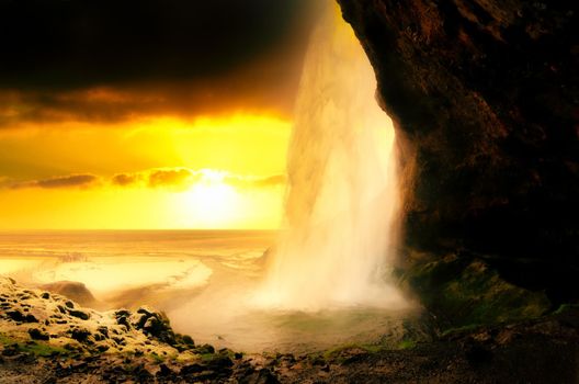 Photo of Seljalandsfoss Waterfall on the South Coast of Iceland bathed in the otherworldly light of the midnight sun with selective focus on the water