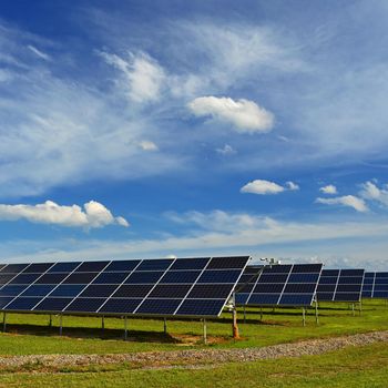 Solar power plant - concept for electricity and ecological industry. High energy prices. Beautiful landscape and sunny day with blue sky.