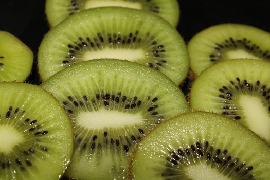 Close-up of kiwi slices on a black background. Fruit background..