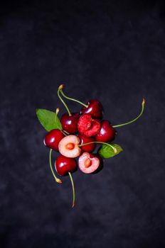 Close up Composition of Cherries Flying in the air on Dark Background.