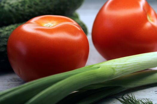 Cucumbers, tomatoes, green onions close-up. The concept of vegetarianism, healthy eating..