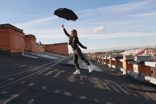 Woman with umbrella is happy on the roof of Saint Petersburg, Russia. Cityscape view over the rooftops of St. Petersburg.