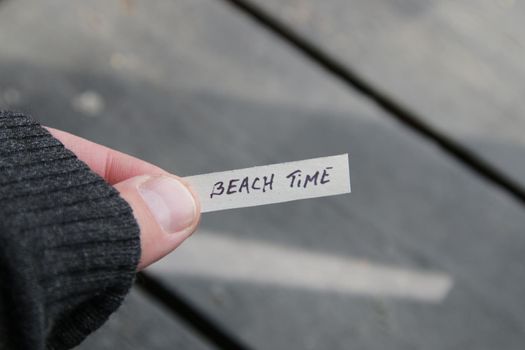 Beach time concept. Paper card with an inscription. Creative summer Vacations idea.