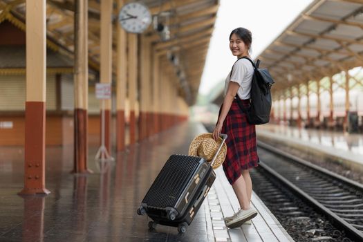 Young traveler woman looking for friend planning trip at train station. Summer and travel lifestyle concept