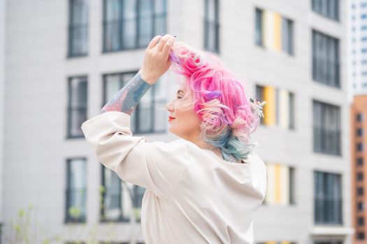 Portrait of a middle-aged woman with multi-colored hair walks on the streets of the city