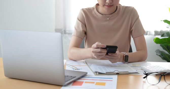 Asian businesswoman relax and enjoy playing mobile phone at office..