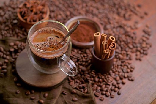 Hot black coffee and coffee beans on the old wooden table