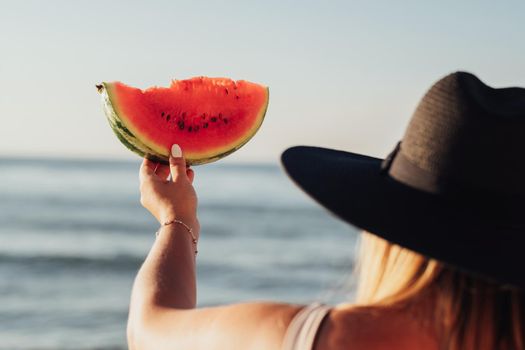 Back View of Woman Holding Piece of Watermelon in Hand Against Sea, Summer Time Concept