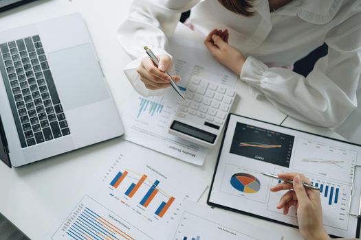 Negotiation, Analysis, Discussion, Asian woman economist and marketer pointing to a financial data sheet to plan investments to prevent risks and losses for the company.