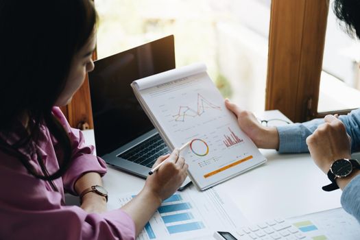 Negotiation, Analysis, Discussion, Asian woman economist and marketer pointing to a financial data sheet to plan investments to prevent risks and losses for the company.