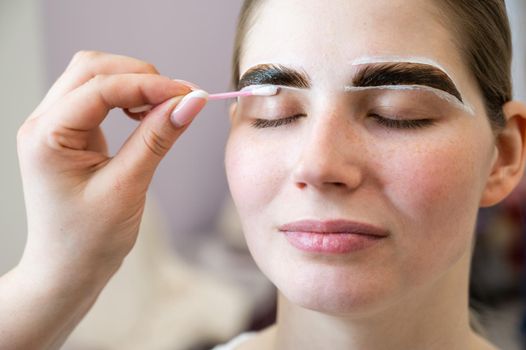 The master paints the eyebrows of a woman