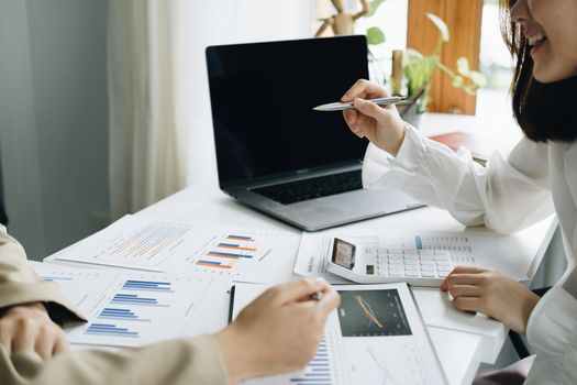 Negotiation, Analysis, Discussion, Asian woman economist and marketer pointing to a financial data sheet to plan investments to prevent risks and losses for the company.