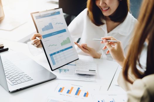 Negotiation, Analysis, Discussion, Asian woman economist and marketer pointing to a financial data sheet to plan investments to prevent risks and losses for the company.