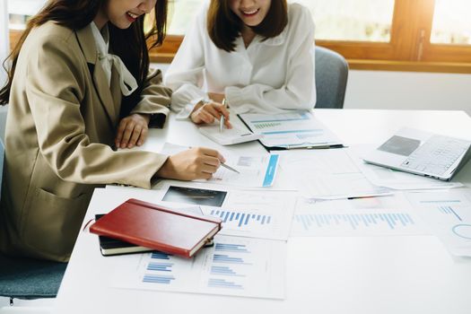 Negotiation, Analysis, Discussion, Asian woman economist and marketer pointing to a financial data sheet to plan investments to prevent risks and losses for the company.