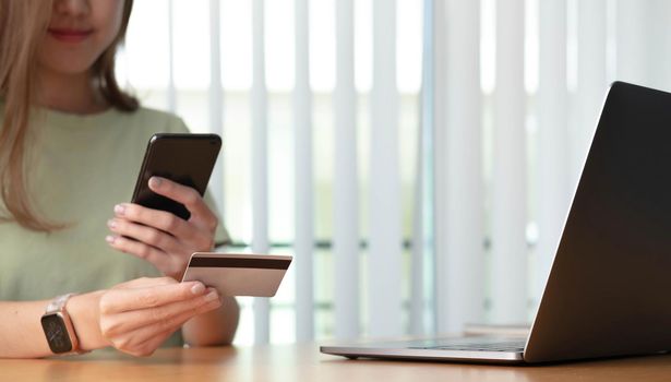 Close up of female hands making online payment with smart phone.