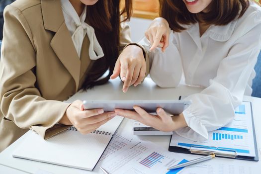 Negotiation, Analysis, Discussion, Asian women economist and marketer using tablet computer to plan investments and financial to prevent risks and losses for the company.