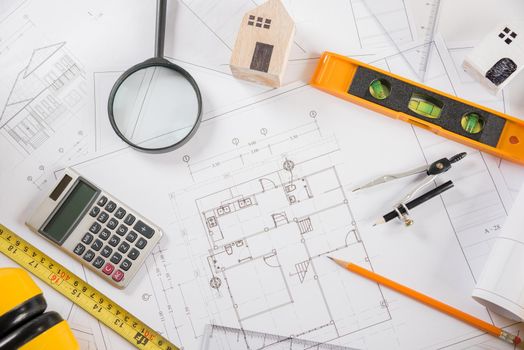 Architectural project workplace. Top view of house plan blueprint paper with repair tools on table desk at architecture office, Engineering architect design tools concept