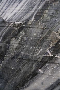 Surface of a cut of gray Karelian marble rock in Ruskeala in Karelia, for use as an abstract background and texture.