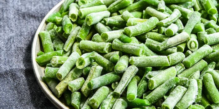 Fresh frozen green beans in a plate. Stocking up vegetables for winter storage. Healthy nutrition. Frozen beans vitamins