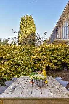 Neat paved patio with sitting area and small garden near wooden fence