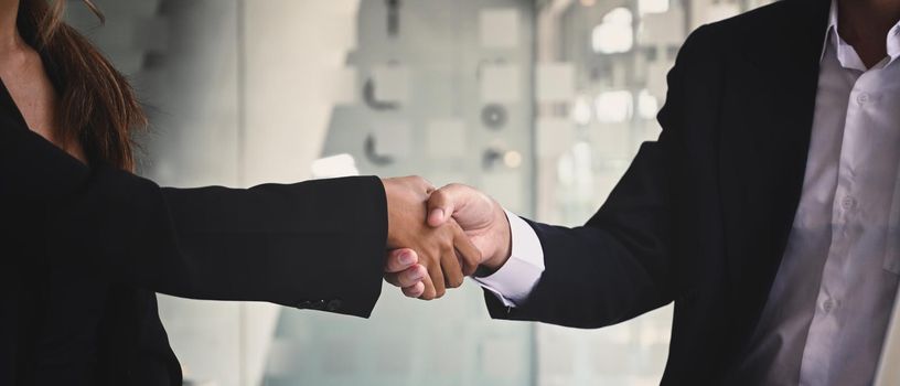 Businesspeople shaking hands after investment deal, finishing up a meeting. Teamwork and partnership concept.