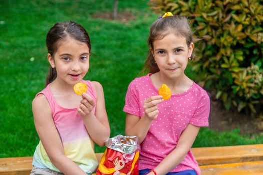 Children eat chips in a friend's park. Selective focus. Kids.