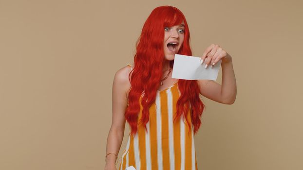 Woman open envelope take out letter reads it feel happy. Career growth advance promotion, bank loan approve, monetary award long-awaited invitation great news. Girl isolated on beige studio background