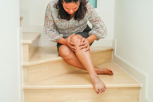 Asian senior woman wearing elastic support knee brace for reduce pain.
