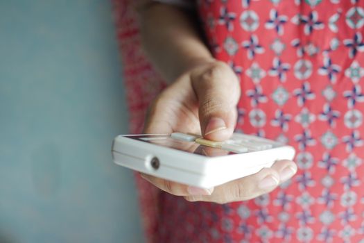 Close up of women hand holding air condition remote .