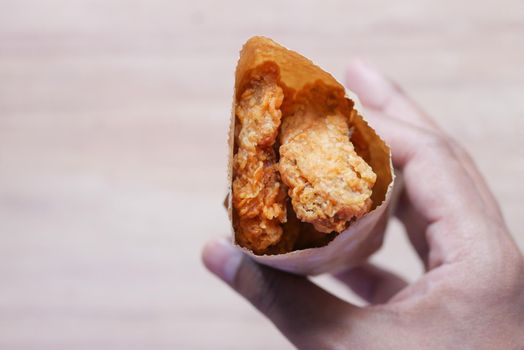 Crispy fried chicken wings in a paper packet .