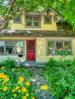 Old residential house in shades of trees on bright sunny day.