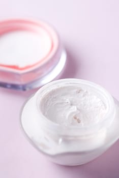 Close up of beauty cream in a pink container.