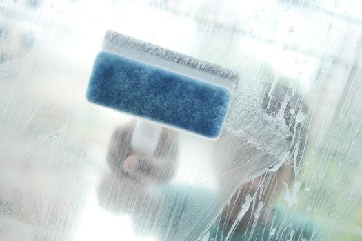 Close up of man hand cleaning window glass .