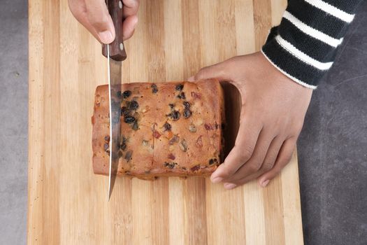 slice of bakery fruit cake on chopping board ,
