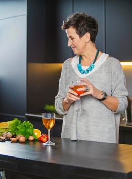 woman with a glass of wine in the kitchen