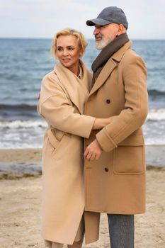 aged couple walking along the seashore