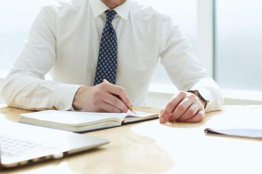 Closeup of business man writing form on clipboard.