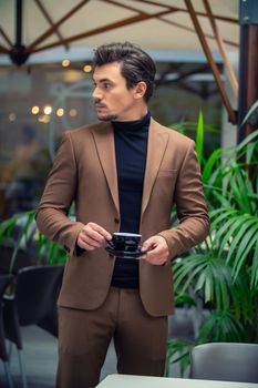 a man in a business suit is drinking tea