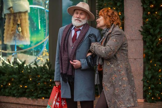 elderly couple on the background of a shop window