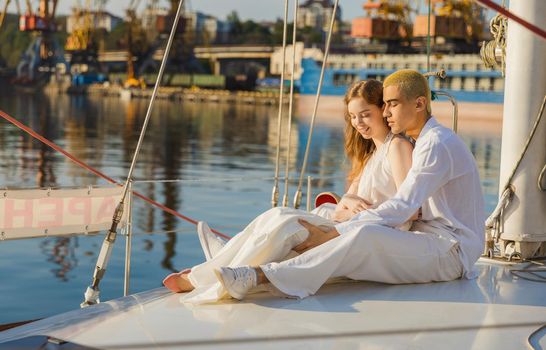 couple in white clothes sitting on board the yacht