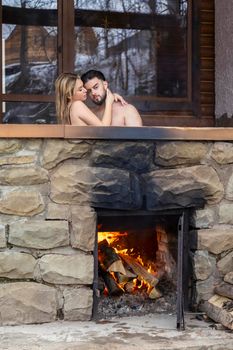 the couple sits in a vat in which the water is heated with the help of firewood