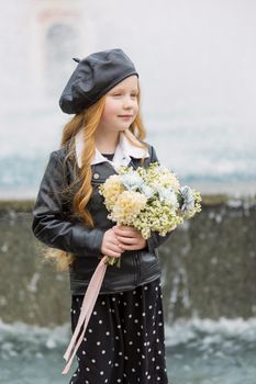 girl with a bouquet of flowers near the fountain