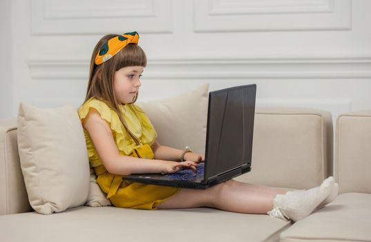 girl sitting on the couch with a laptop