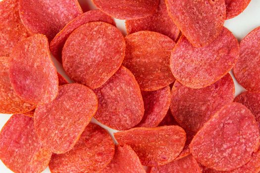 Red chips with hot pepper taste on a white background. Beer snack. Close-up