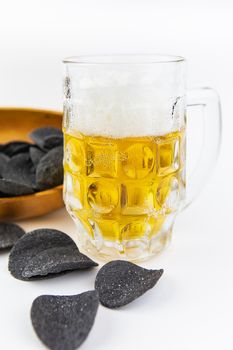 Beer background. Fresh beer and potato chips in a wooden plate. Free space for text