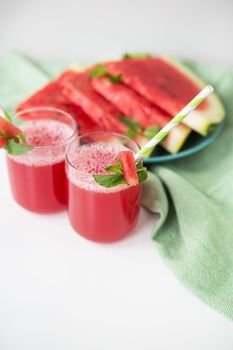 A glass of freshly squeezed fresh watermelon juice, a healthy watermelon and mint leaf smoothie