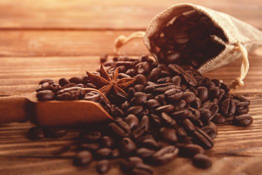 Close up of roasted coffee beans with anise in sackcloth bag on a wooden background Coffee is always a good idea